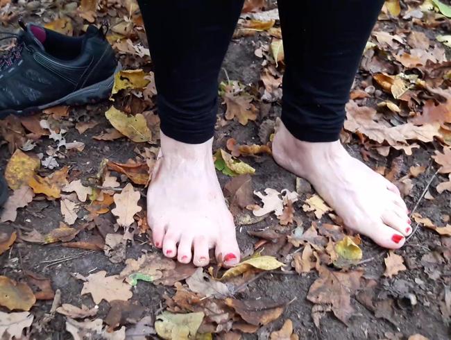 Nackte Füße im Laub